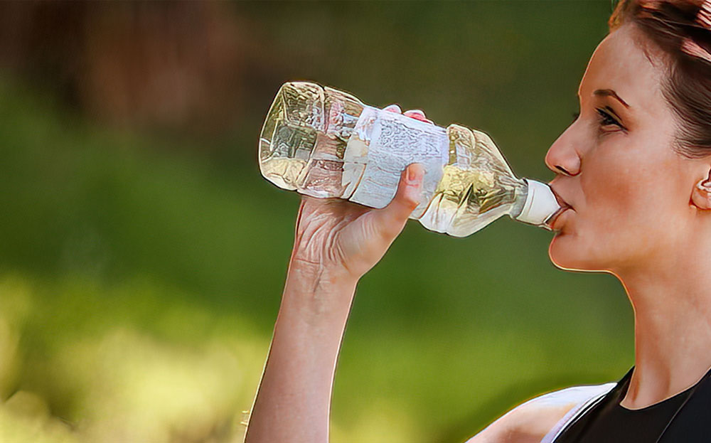 Woman drinking from water bottle